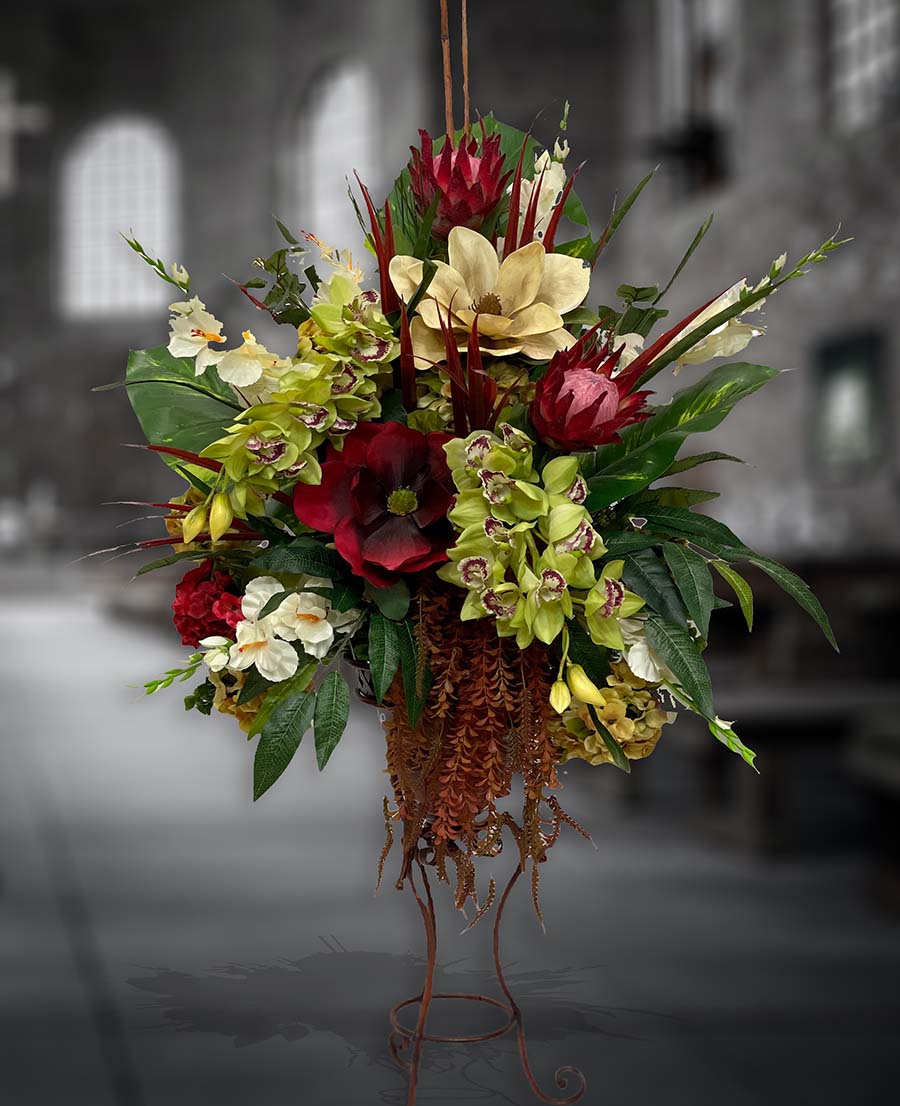 Red and white silk flower arrangement in a stand for a church decor